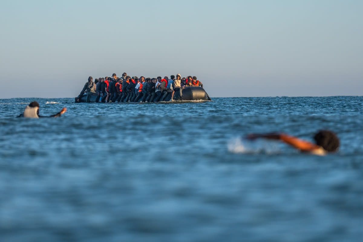 أشخاصٌ يسبحون من أجل اللحاق بقاربٍ صغيرٍ للمهاجرين في القناة الإنجليزية - في 25 أغسطس/آب 2025 في غرافلين، فرنسا.
