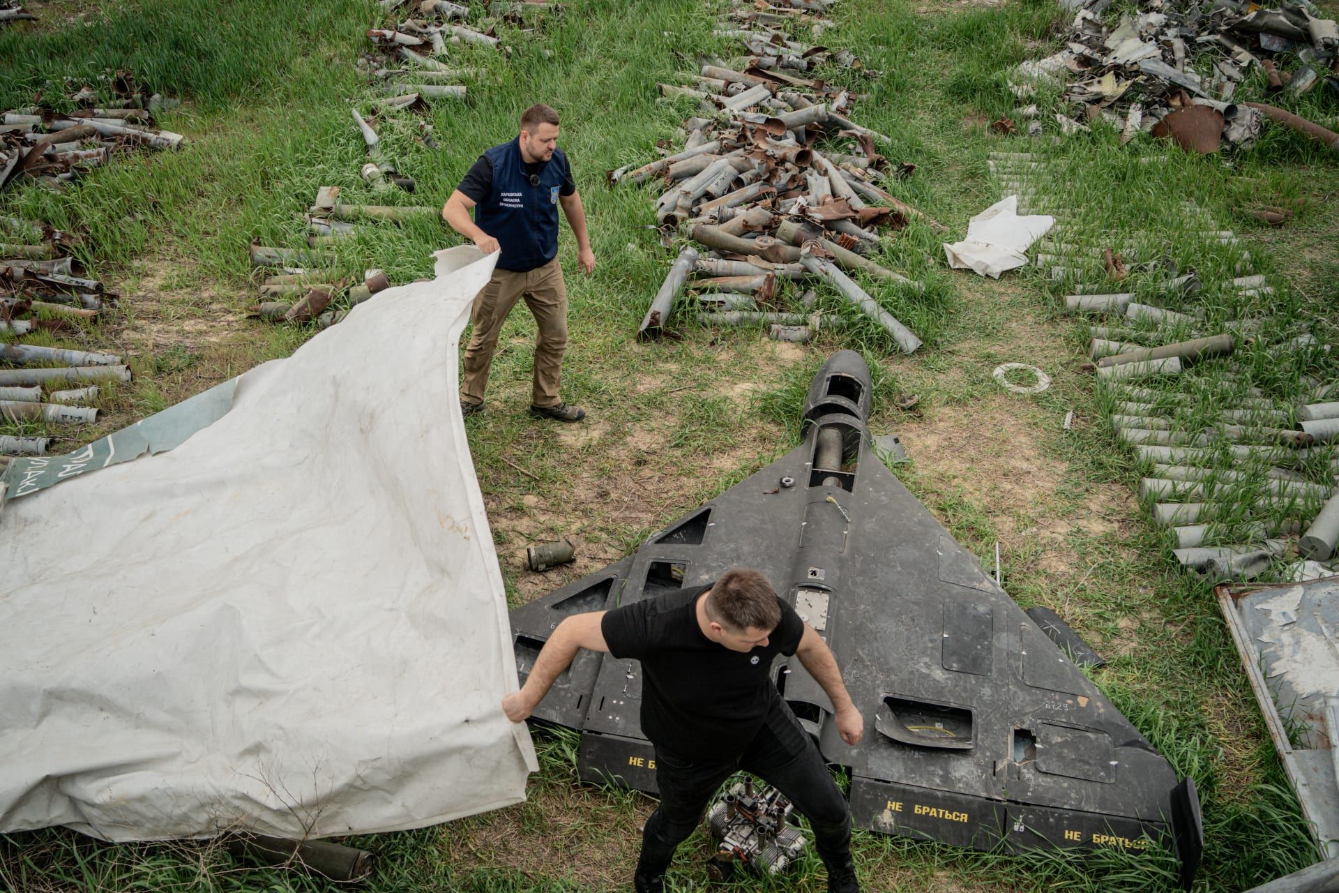 دميترو تشوبينكو، المتحدث باسم المدعي العام في خاركيف، ومساعده يغطيان طائرة روسية بدون طيار من طراز